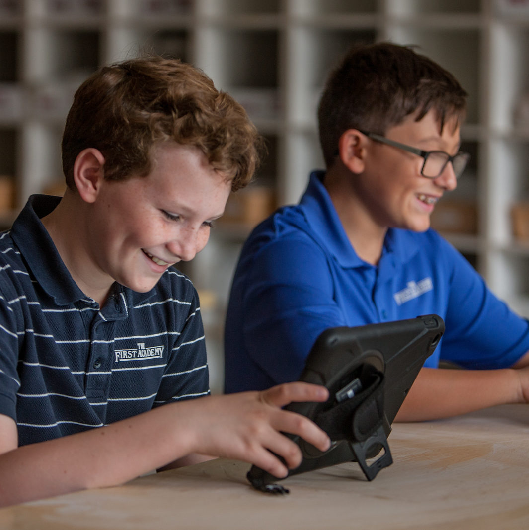 Two young boys using tablets